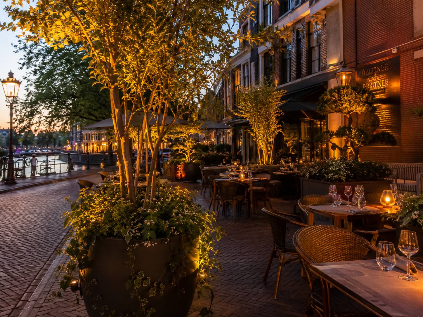 Horecaterras met groene afscheiding en sfeerverlichting